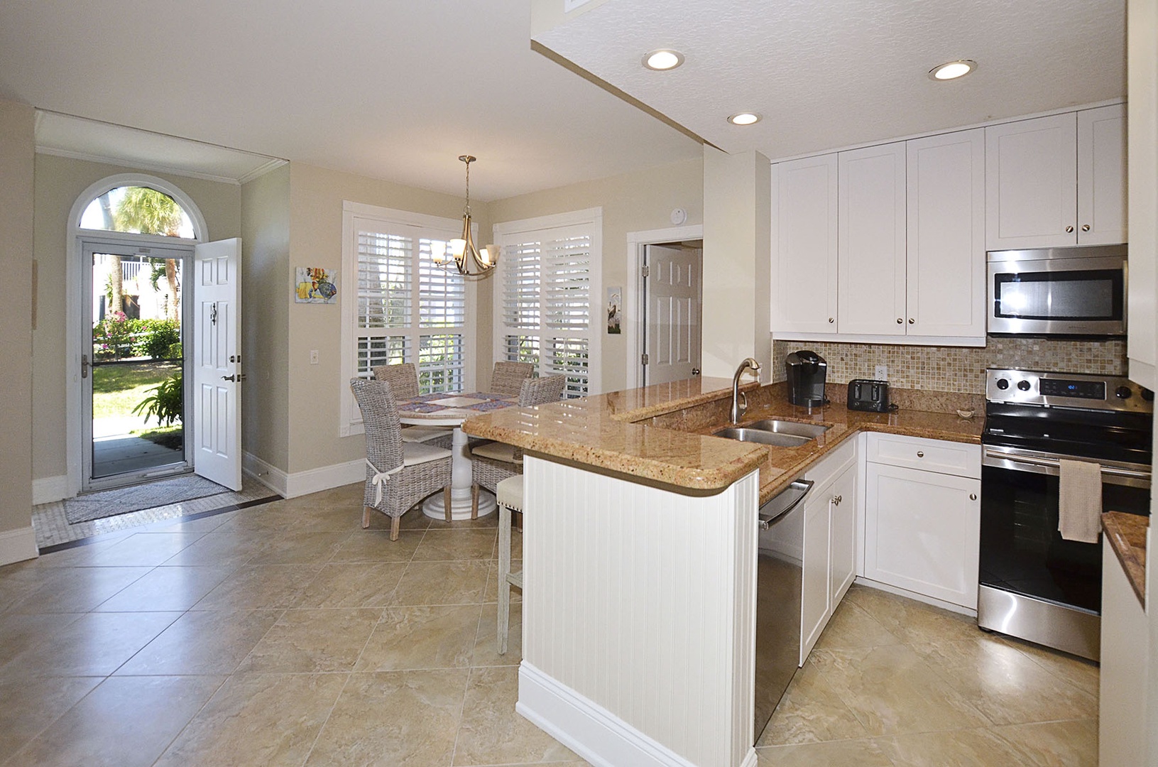 Your bright kitchen flows into a cozy dining nook, perfect for morning coffee or preparing meals while enjoying garden views.