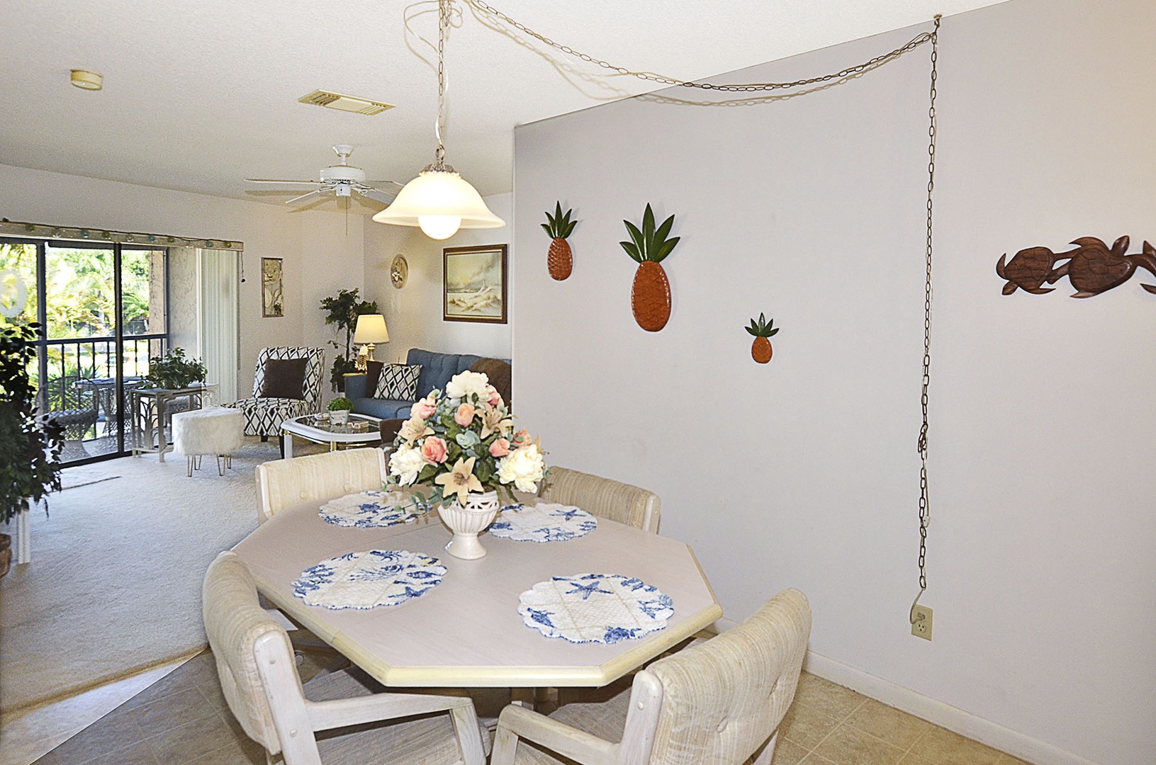 Enjoy tropical comfort in your open-plan dining area, where pineapple art adds playful island charm to shared meals and conversations.