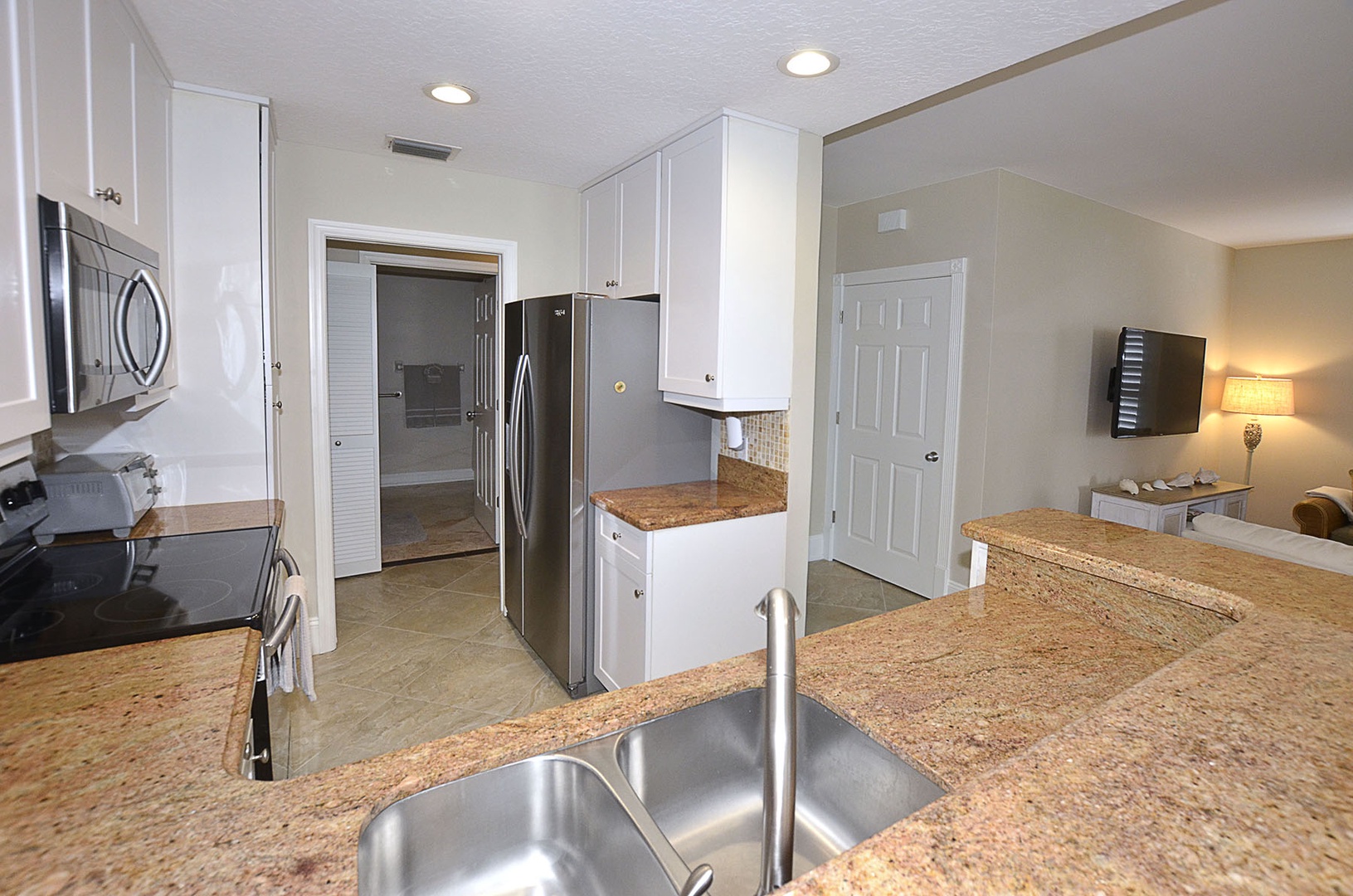 Fully equipped kitchen features stainless steel appliances, and ample storage for preparing meals during your stay.