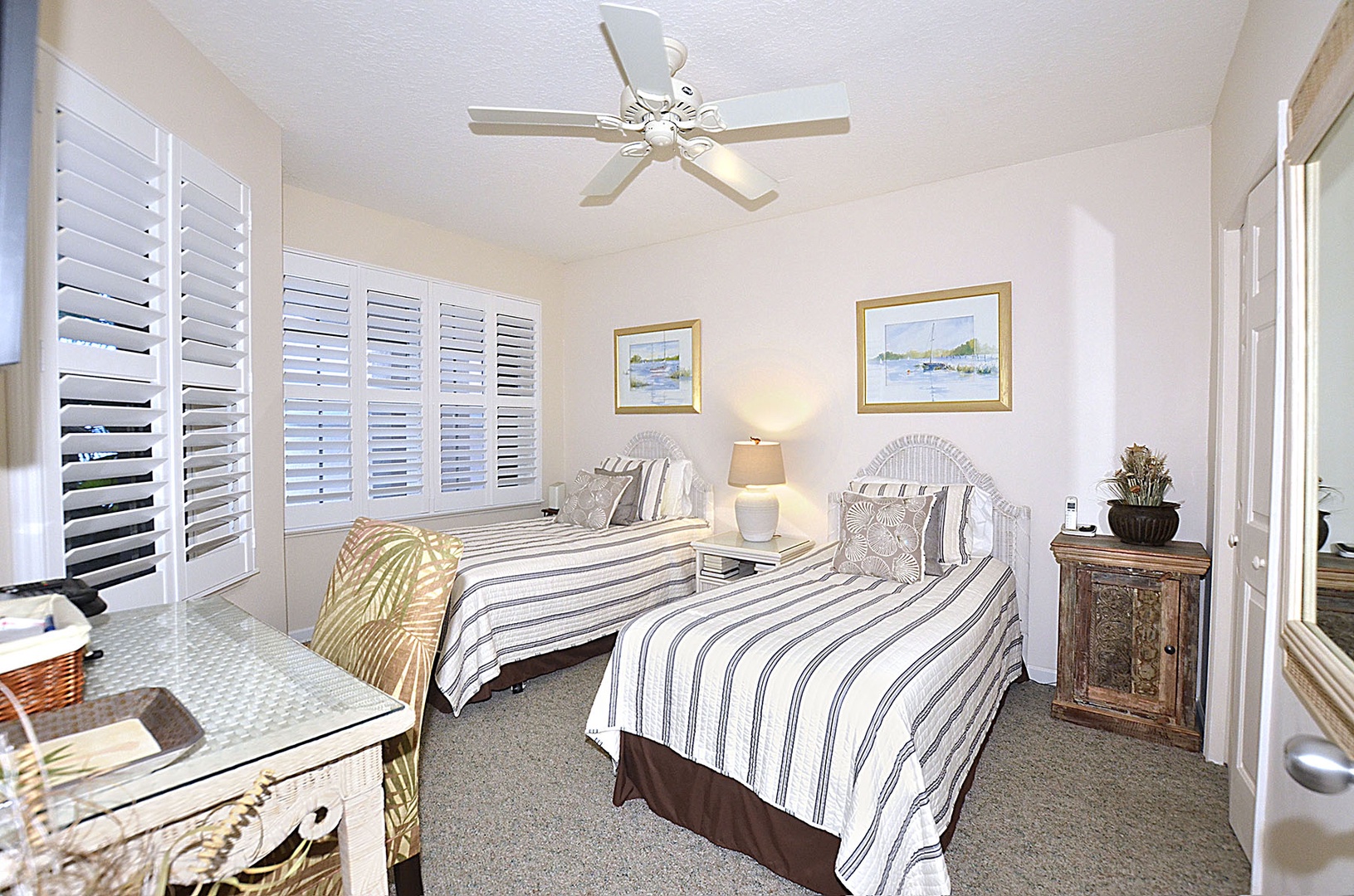 Drift off in this peaceful Guest Bedroom with coastal charm and gentle ceiling fan breezes for your perfect night's rest.