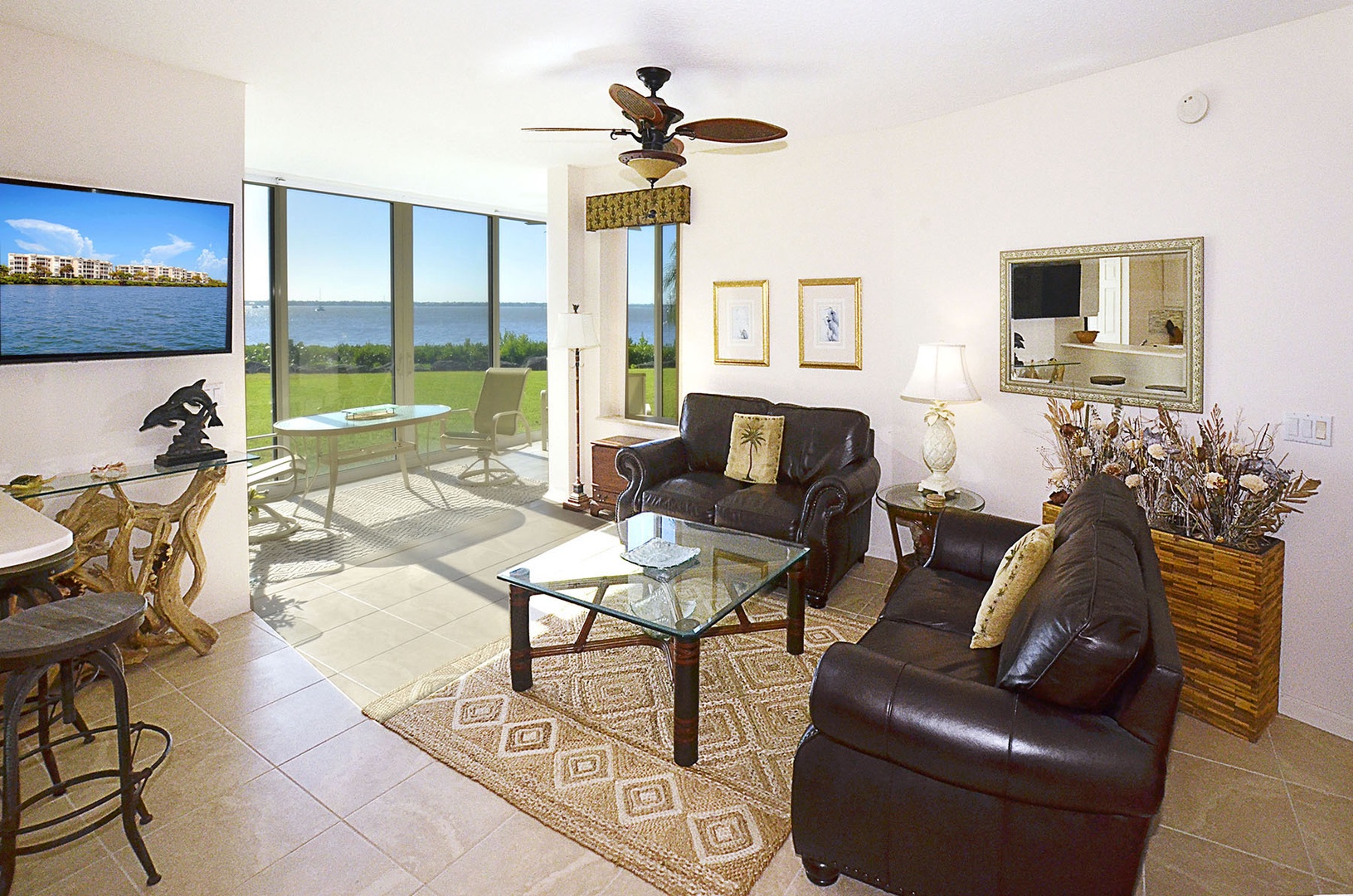 Sink into plush leather seating while enjoying stunning waterfront views through floor-to-ceiling windows in your bright, elegant living space.