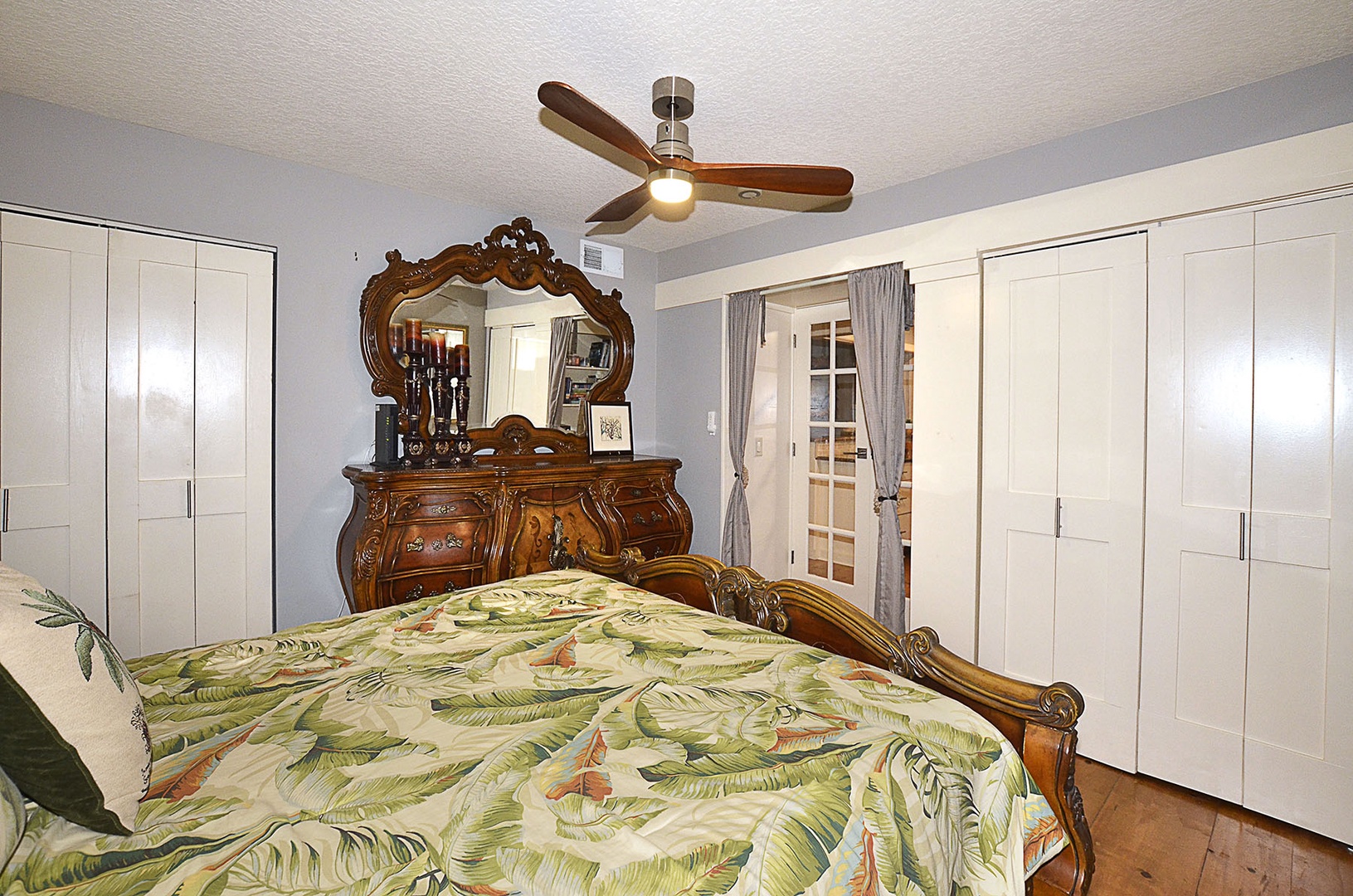 Guest Bedroom. Rest peacefully in your tropical-themed bedroom featuring ornate wood furnishings and ceiling fan.