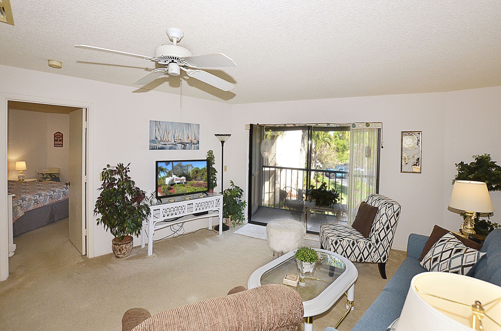 Relax in your bright living room with comfortable seating, ceiling fan, and sliding doors opening to your private balcony.