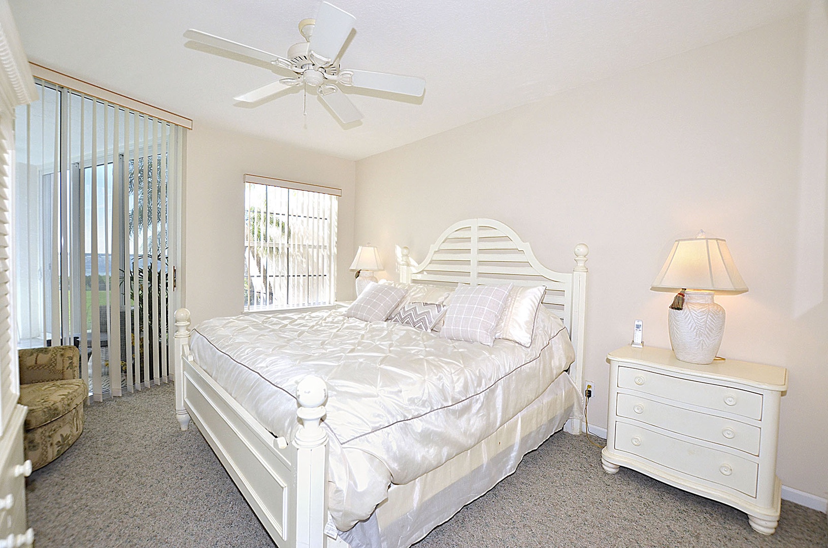The Primary Bedroom features a serene environment with a comfortable king size bed, gentle ceiling fan, and soft natural light.