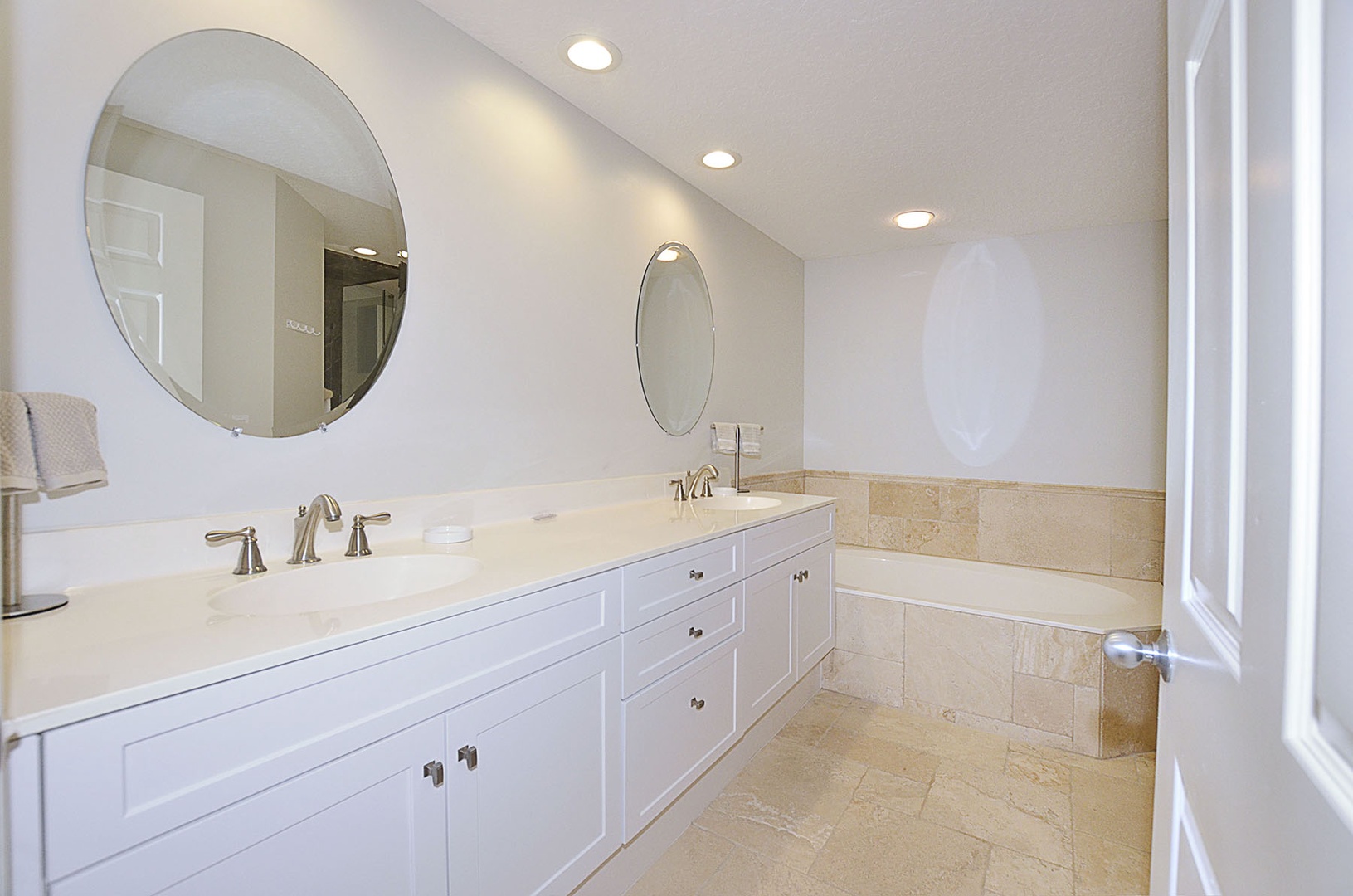 Indulge in your private spa-like bathroom featuring elegant marble details, dual vanities, and a luxurious soaking tub for ultimate relaxation.