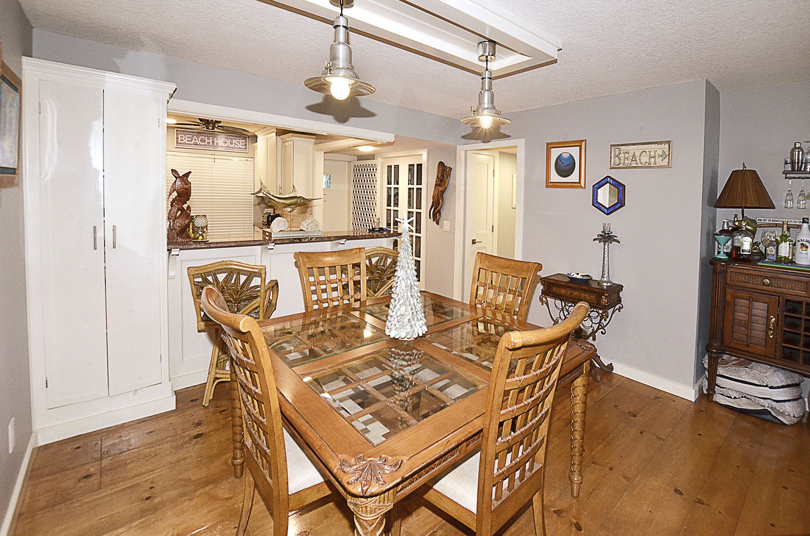 Dining Area. Gather around your elegant glass-top dining table where nautical charm meets comfort, perfect for memorable meals together.