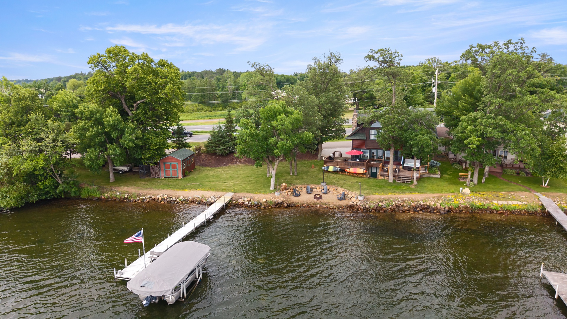 Aerial view of shore, dock, house and yard.