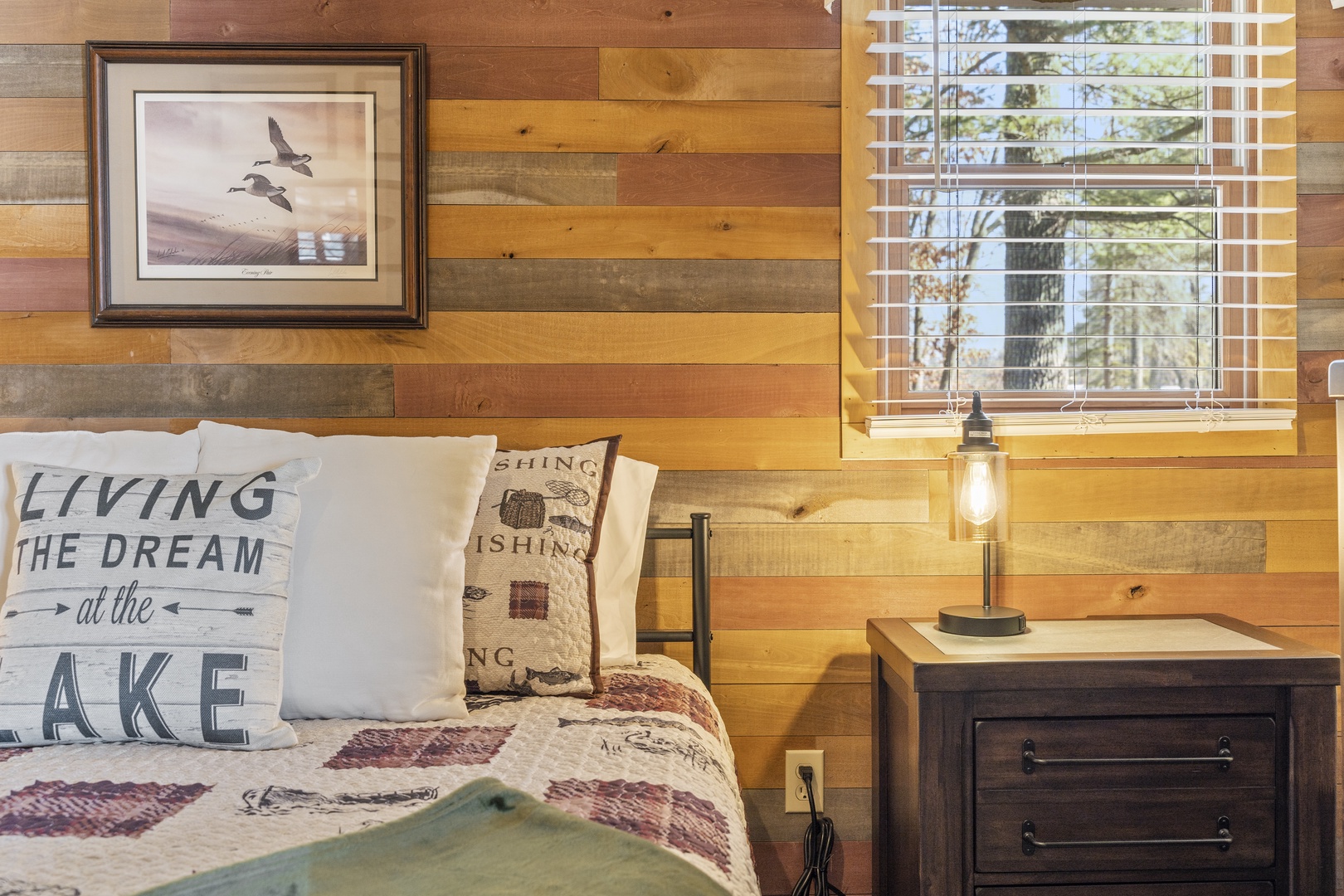 Drift off to sleep surrounded by warm reclaimed wood walls and rustic charm in your cozy lakeside bedroom retreat.