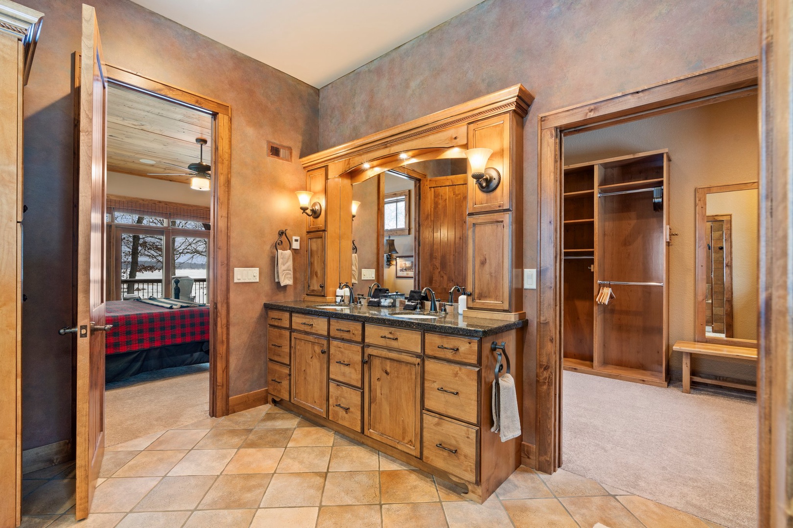 Step into your luxurious bathroom featuring rich wood cabinetry, dual vanities, and elegant lighting that creates the perfect spa-like retreat.