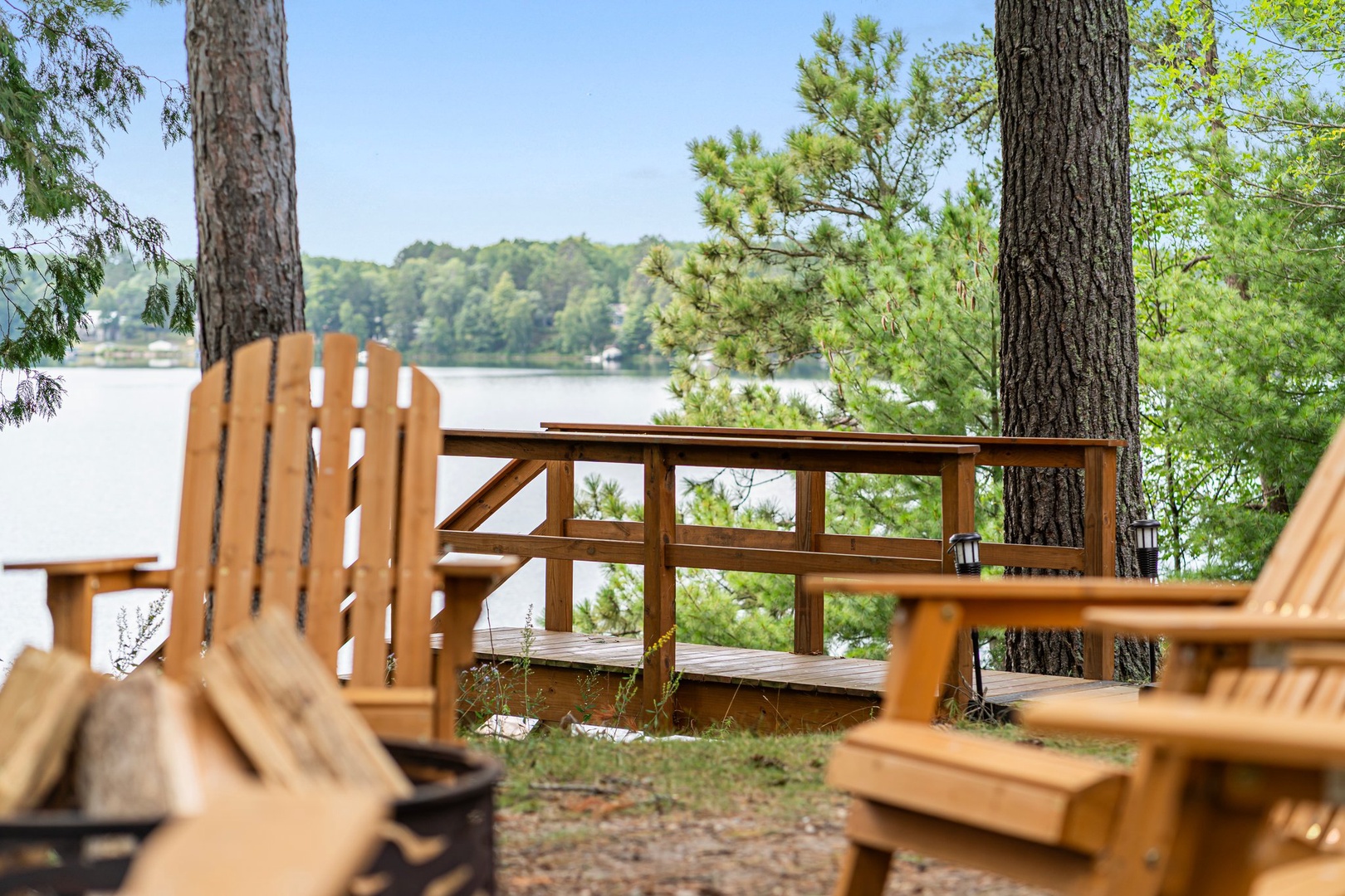 Unwind in your private Adirondack chairs while soaking up stunning lake views through towering pines—your perfect lakeside retreat awaits.