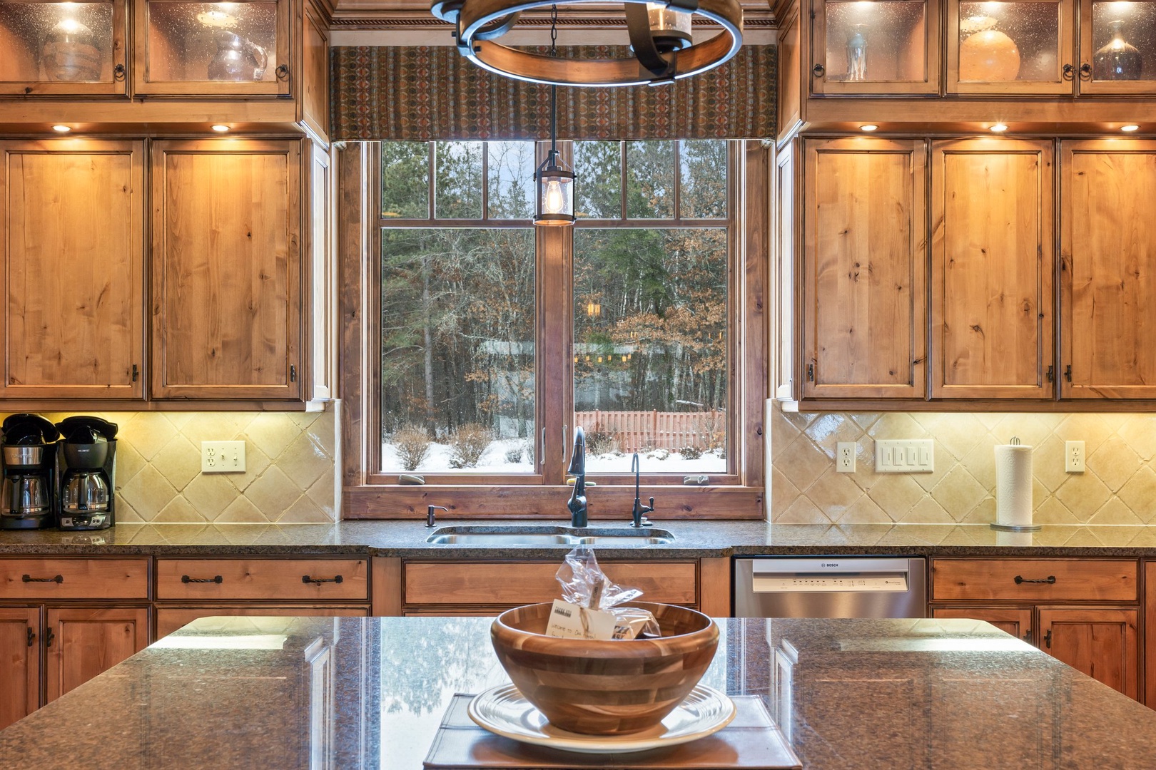 Your fully-equipped kitchen features warm wood cabinetry, granite countertops, and modern appliances—perfect for preparing meals while enjoying peaceful views.