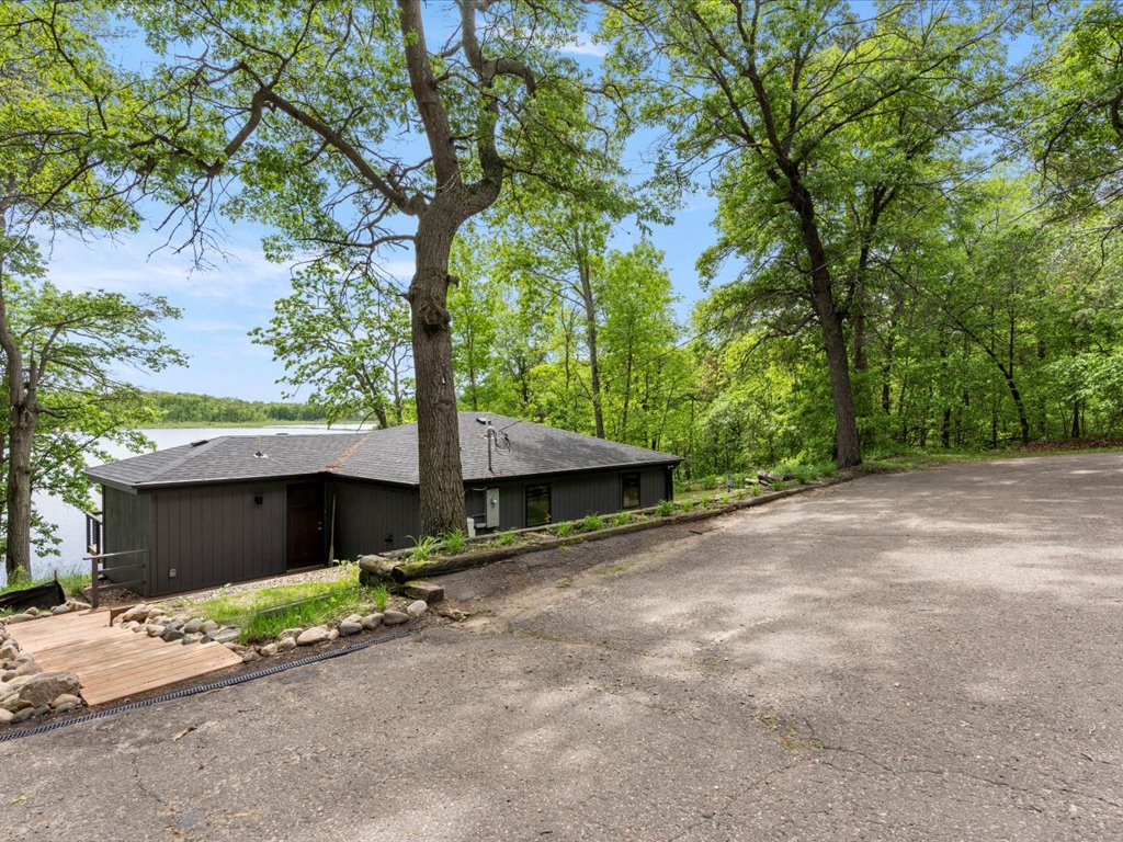 Lakefront retreat nestled among mature trees with convenient parking and peaceful natural surroundings just steps from the water's edge.