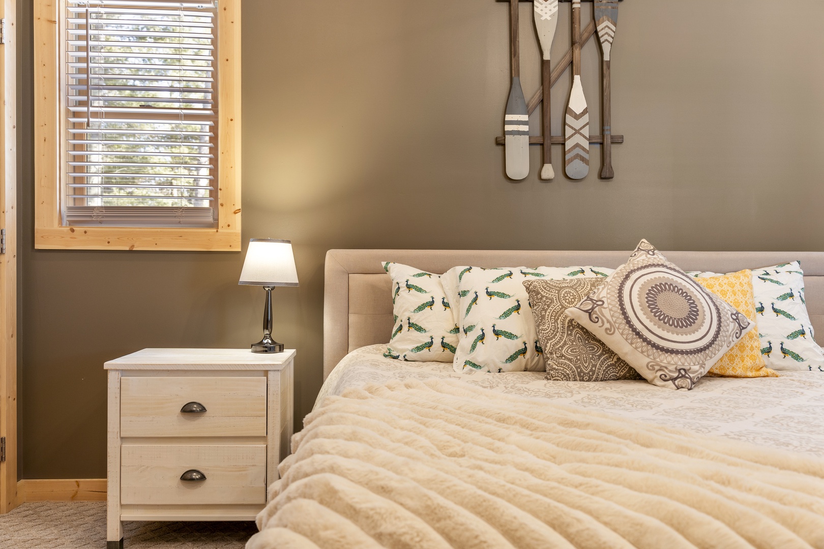 Sink into your cozy bedroom retreat with thoughtfully arranged pillows and warm nautical touches that invite peaceful nights.