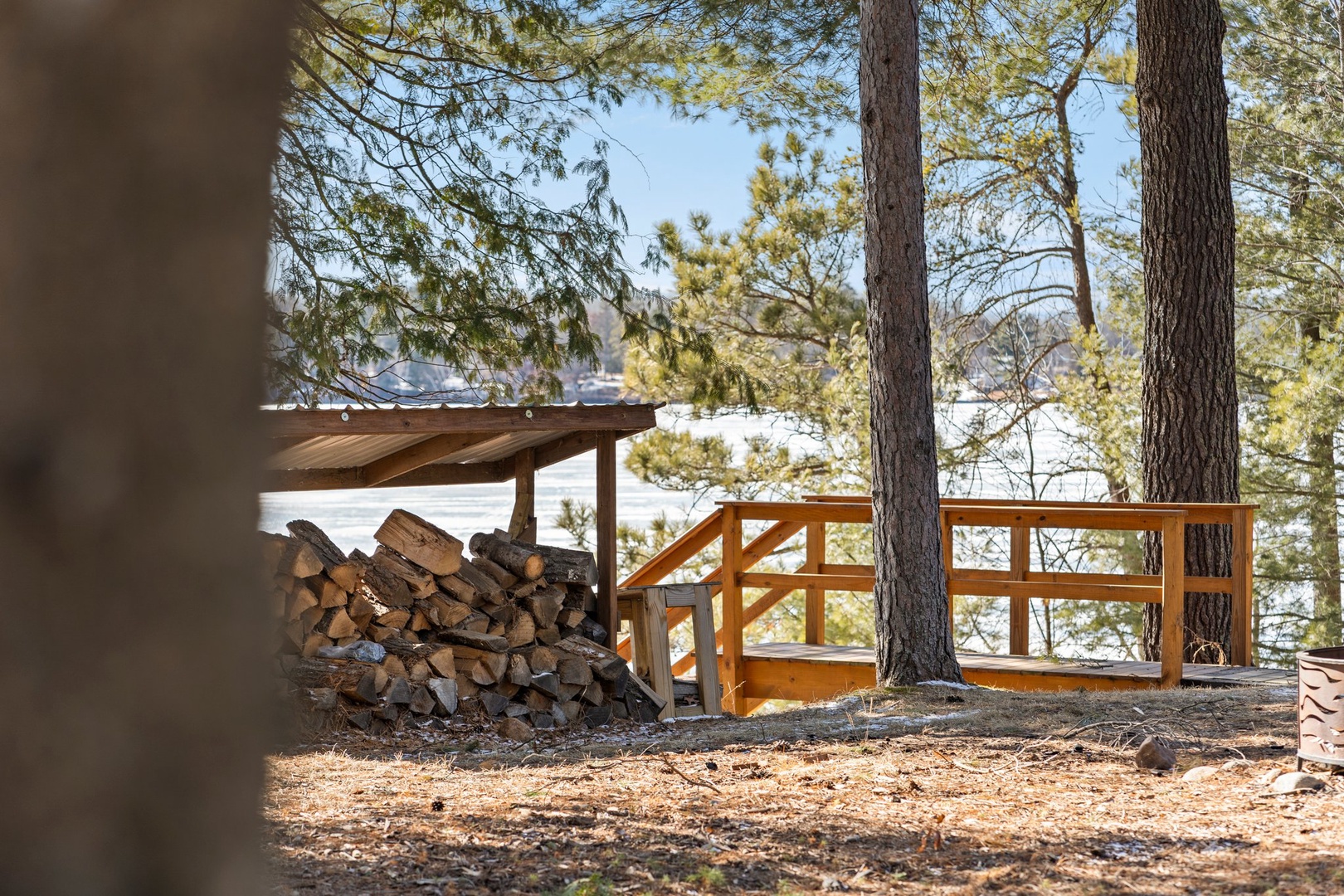 Firewood included and firepit create your perfect lakefront retreat setting among towering pines.