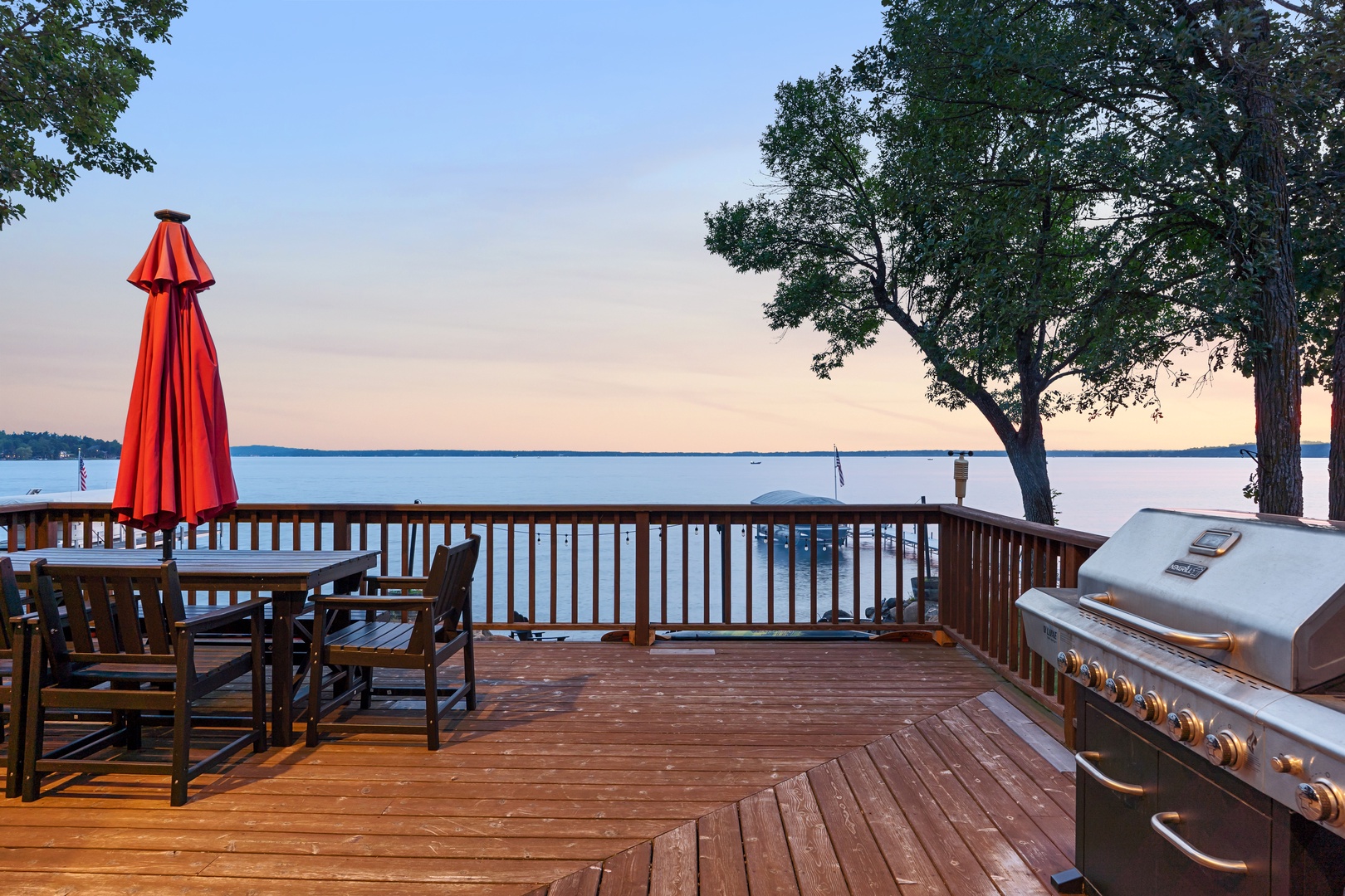 Deck with grill and lake views at sunset.