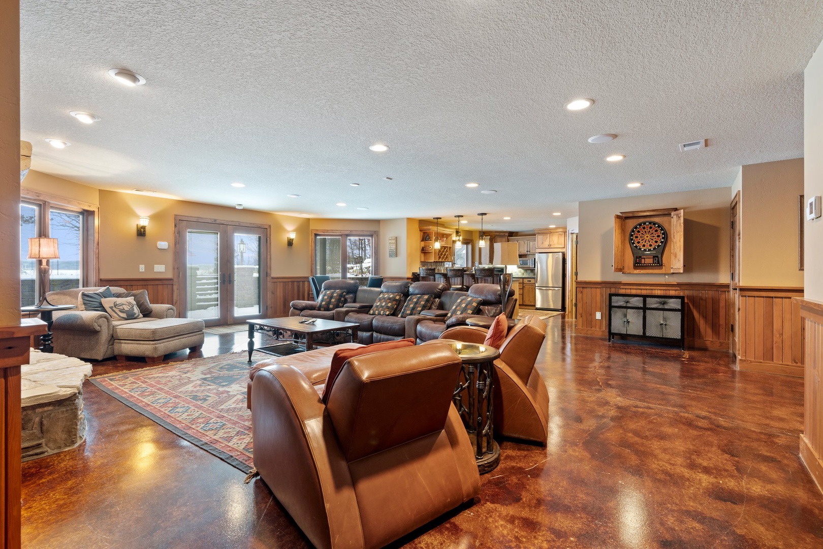 Unwind in your spacious open-concept living area featuring rich leather seating, polished floors, and a cozy fireplace for memorable evenings.