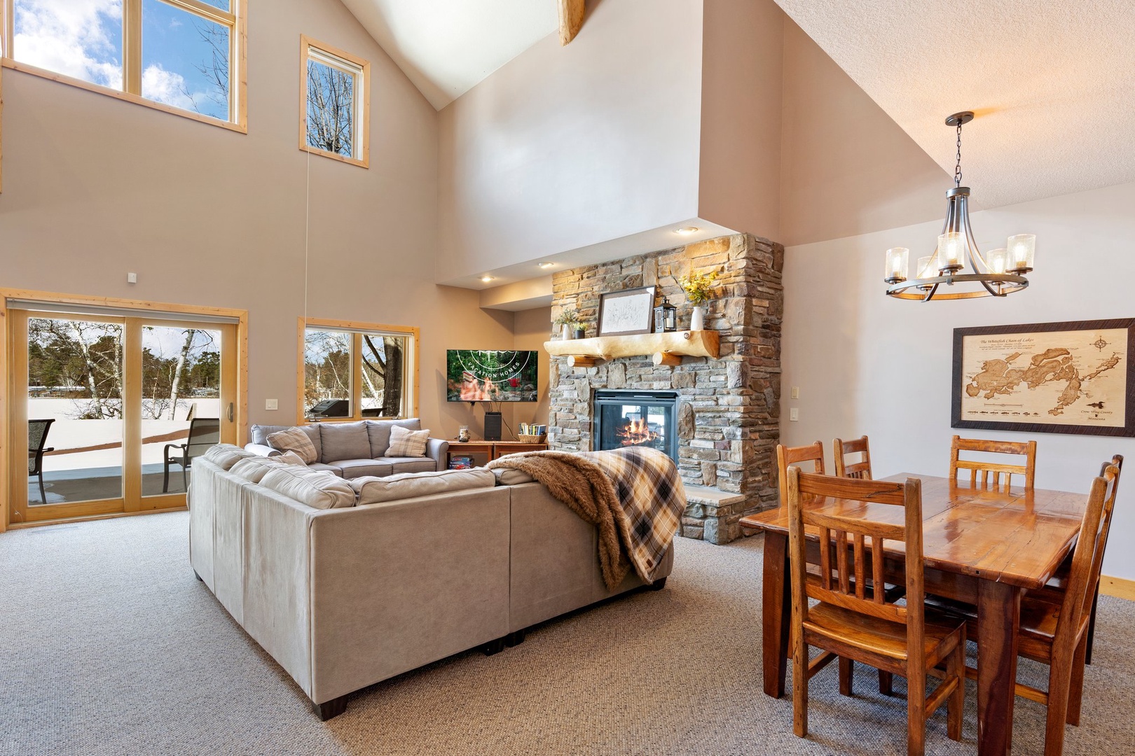 Unwind in your spacious great room where soaring ceilings, a stone fireplace, and plush seating create the perfect gathering spot for cozy evenings.