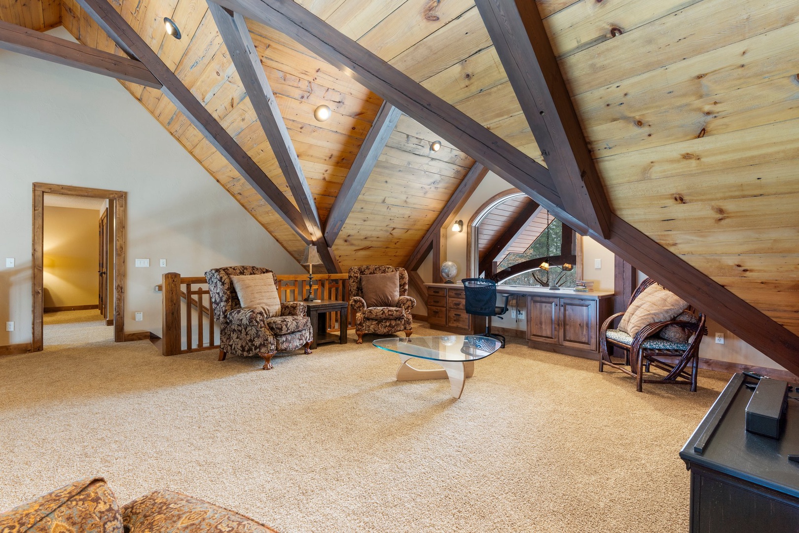 Escape to your private attic retreat with exposed beams and cozy seating where you can unwind completely.