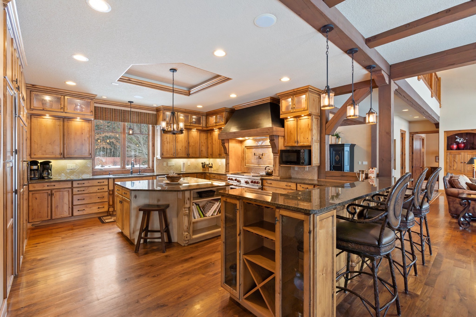 Cook memorable meals in your gourmet kitchen with professional appliances, granite counters, and rustic wood beams overhead.