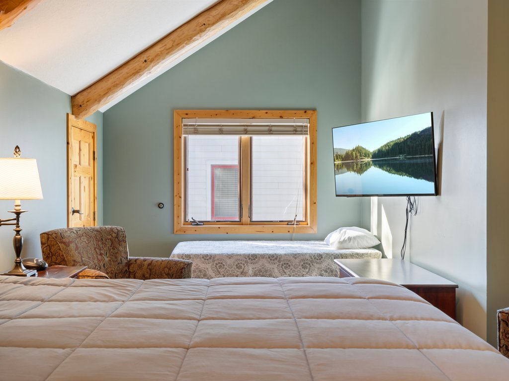 Unwind in your peaceful bedroom, a cozy reading chair, and modern amenities including a wall-mounted TV for your evening entertainment.