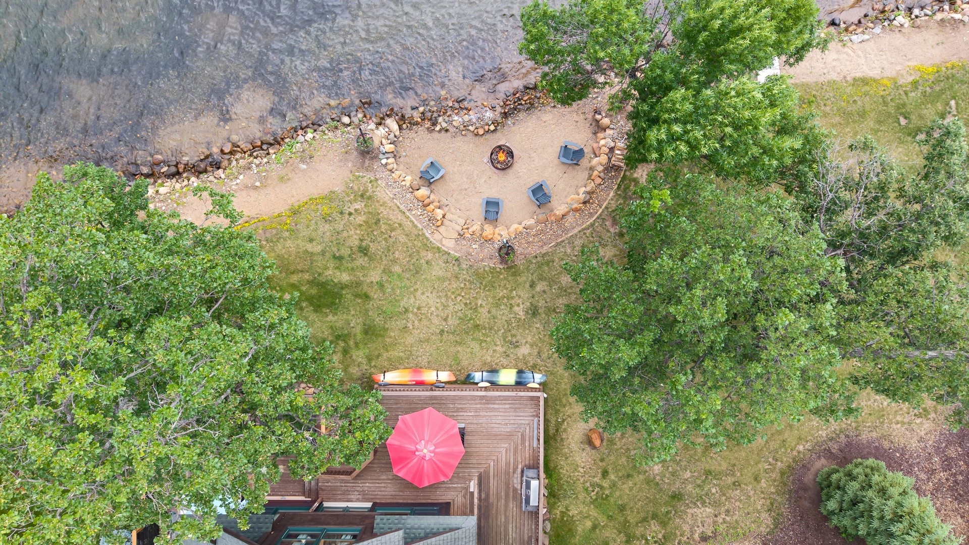 Aerial view overlooking the deck, backyard and dock.