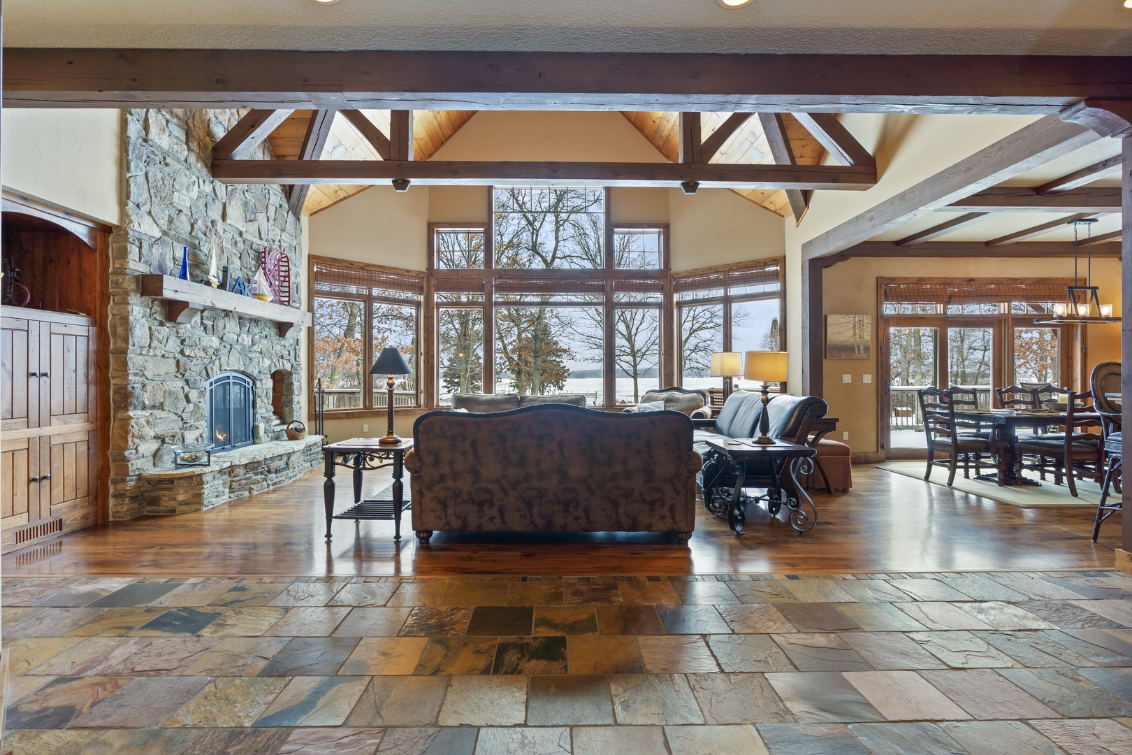 Relax in your spacious living room with soaring beams, stone fireplace, and stunning lake views through floor-to-ceiling windows.