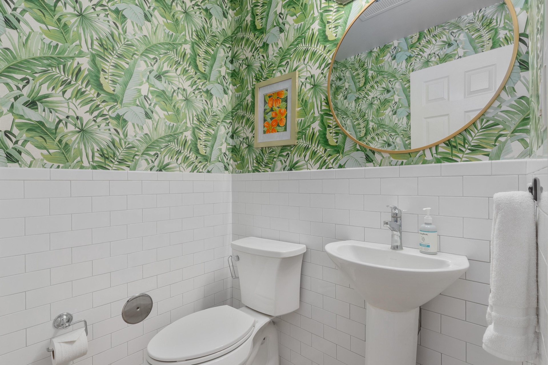 Your powder room enchants with tropical wallpaper and crisp subway tiles—a stylish retreat.
