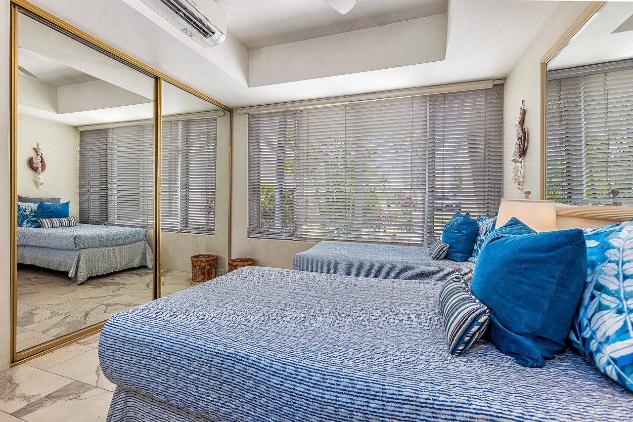 Your coastal retreat awaits with plush bedding in soothing blues, natural light filtering through soft blinds, and a mirrored wardrobe expanding the airy feel of your private sanctuary.