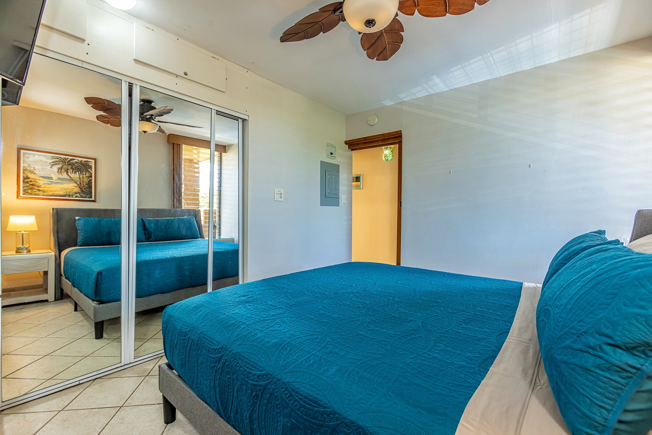 Slip into your coastal-inspired bedroom, where tropical ceiling fans and vibrant turquoise bedding invite you to unwind. Mirrored closet doors create an airy feel, perfect for your island retreat.