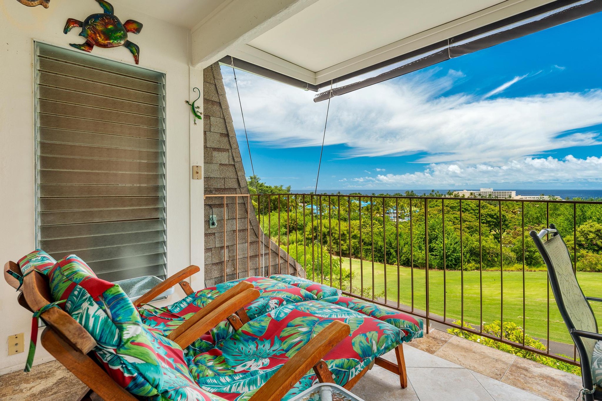Unwind on your private covered lanai with tropical lounge chairs while soaking in panoramic ocean views and lush green landscapes.