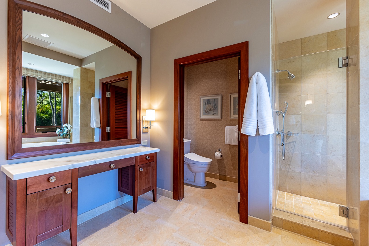 Step into this elegantly appointed bathroom, where rich wood accents meet spa-like tranquility. Refresh in your spacious walk-in shower or unwind at the vanity—everything you need for a rejuvenating escape.
