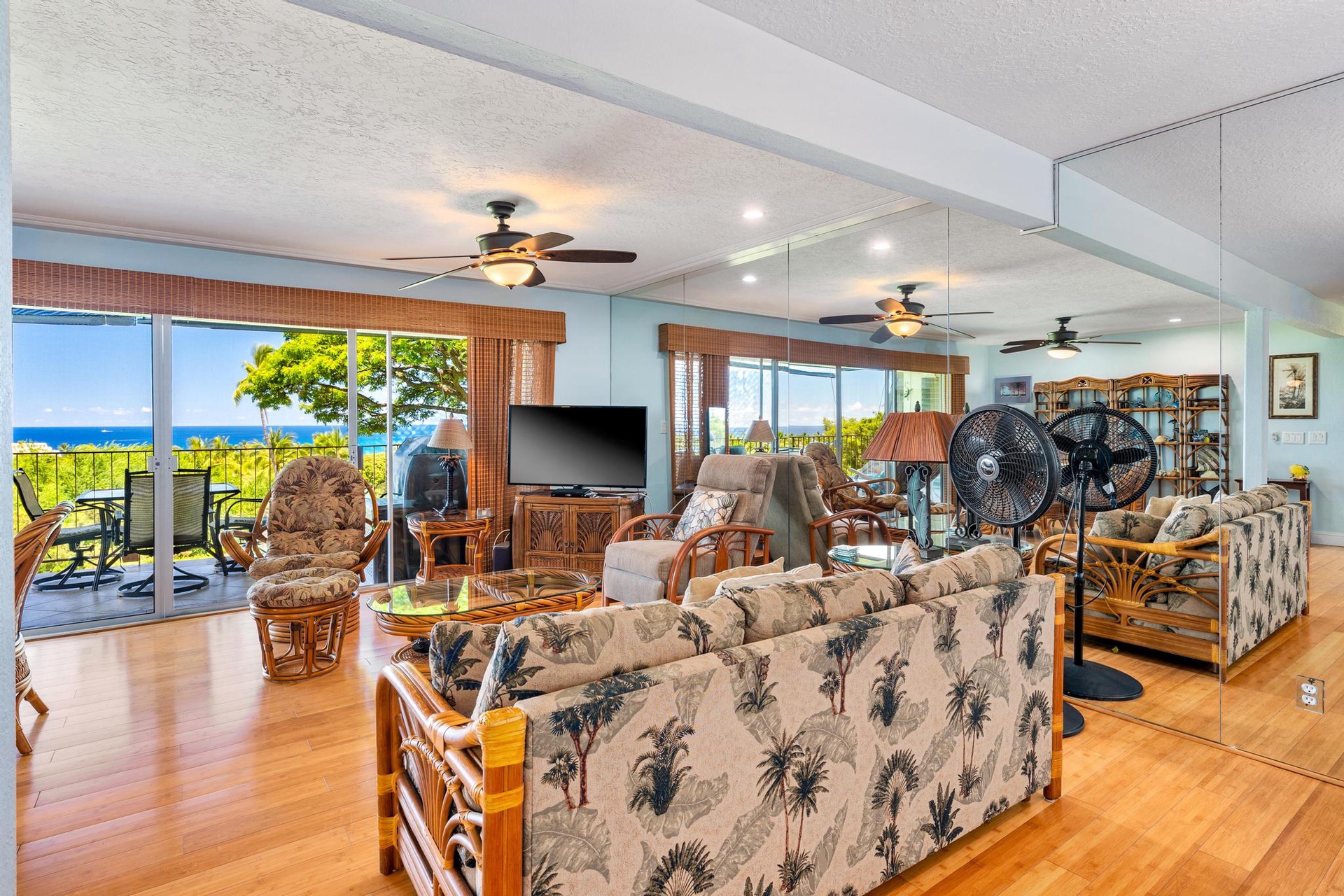 Relax in your tropical-themed living room with stunning ocean views through floor-to-ceiling windows and comfortable seating for the whole family.