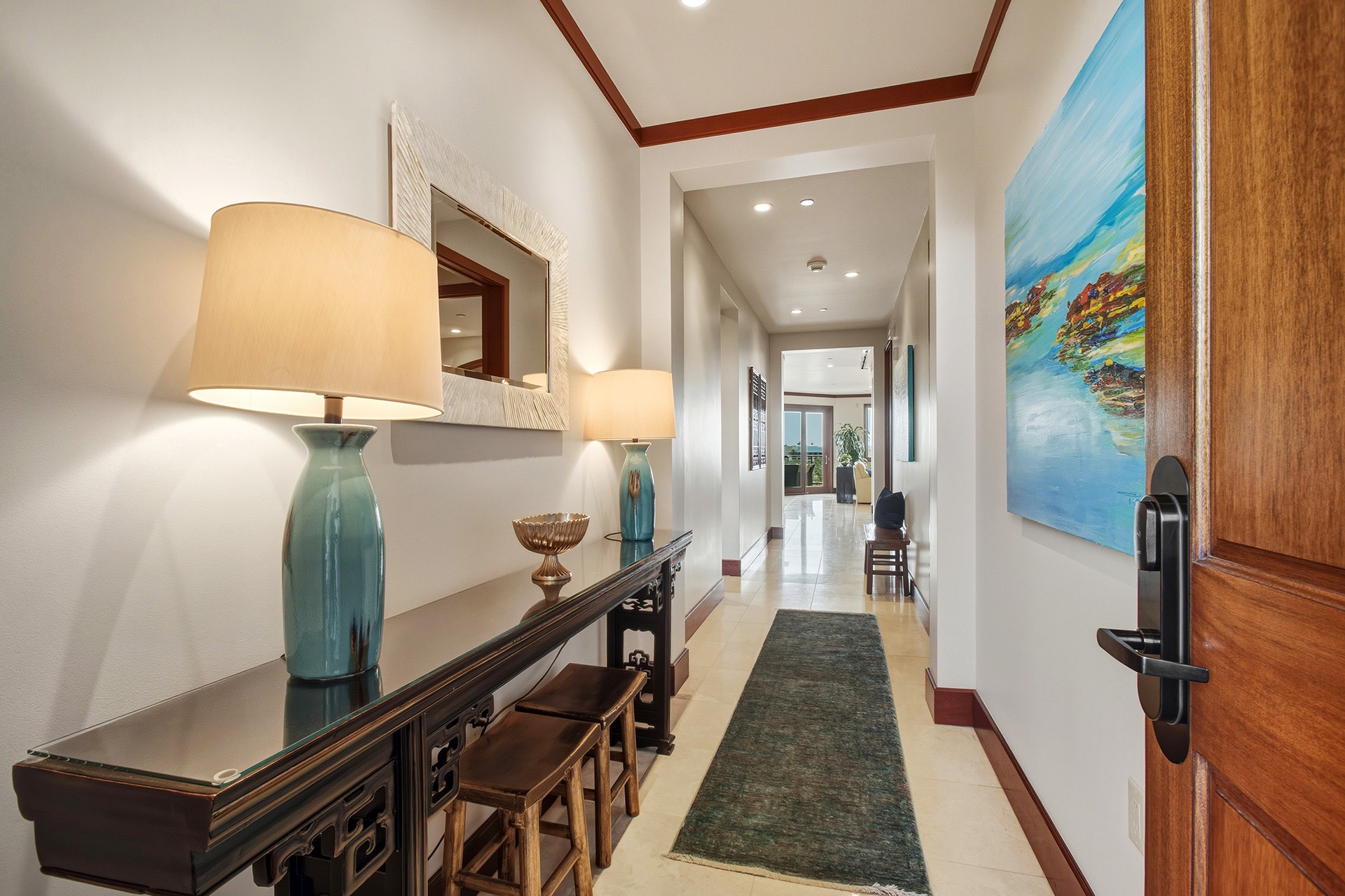 Step into your elegant entryway where coastal artwork and warm lighting create an inviting welcome home.