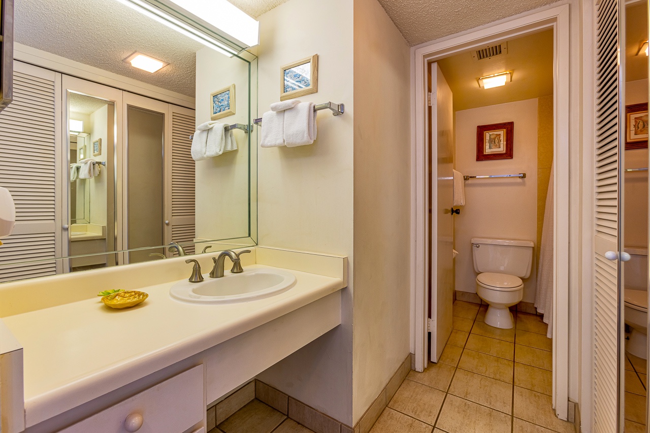 Step into your bright, inviting bathroom with a spacious vanity and fresh towels awaiting your arrival. A separate toilet area offers added privacy and convenience during your stay.