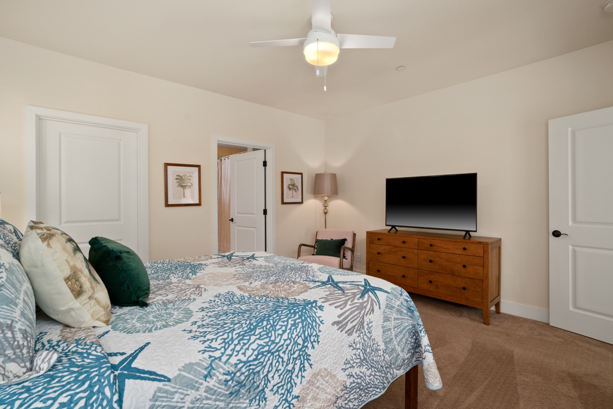 Drift off in your serene bedroom with coastal-themed linens, ceiling fan comfort, and entertainment ready for peaceful evenings.