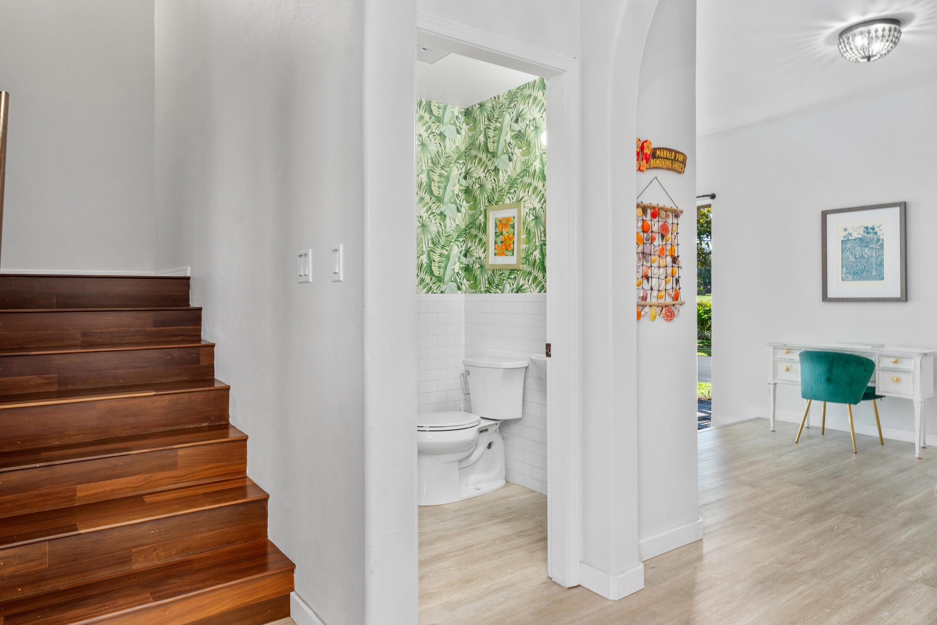 Your stylish powder room features vibrant tropical wallpaper and modern fixtures, creating a cheerful spot that's both functional and fun.