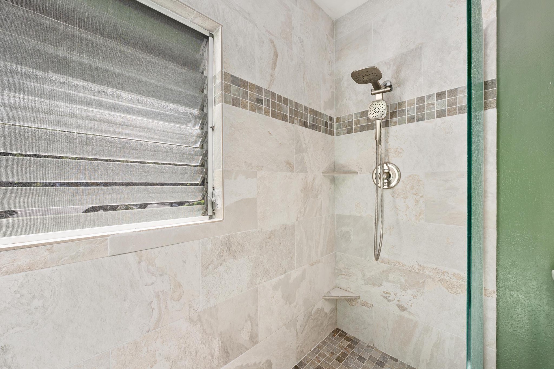 Step into your elegant marble shower featuring beautiful tile accents and modern fixtures for a refreshing start to your day.
