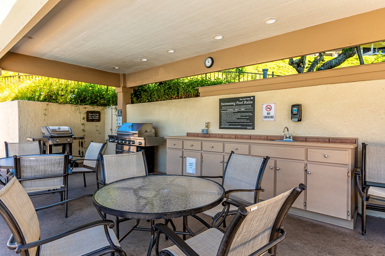 Gather with loved ones in this covered outdoor space featuring BBQ grills, dining tables, and a convenient prep sink—perfect for your poolside cookouts and al fresco meals.