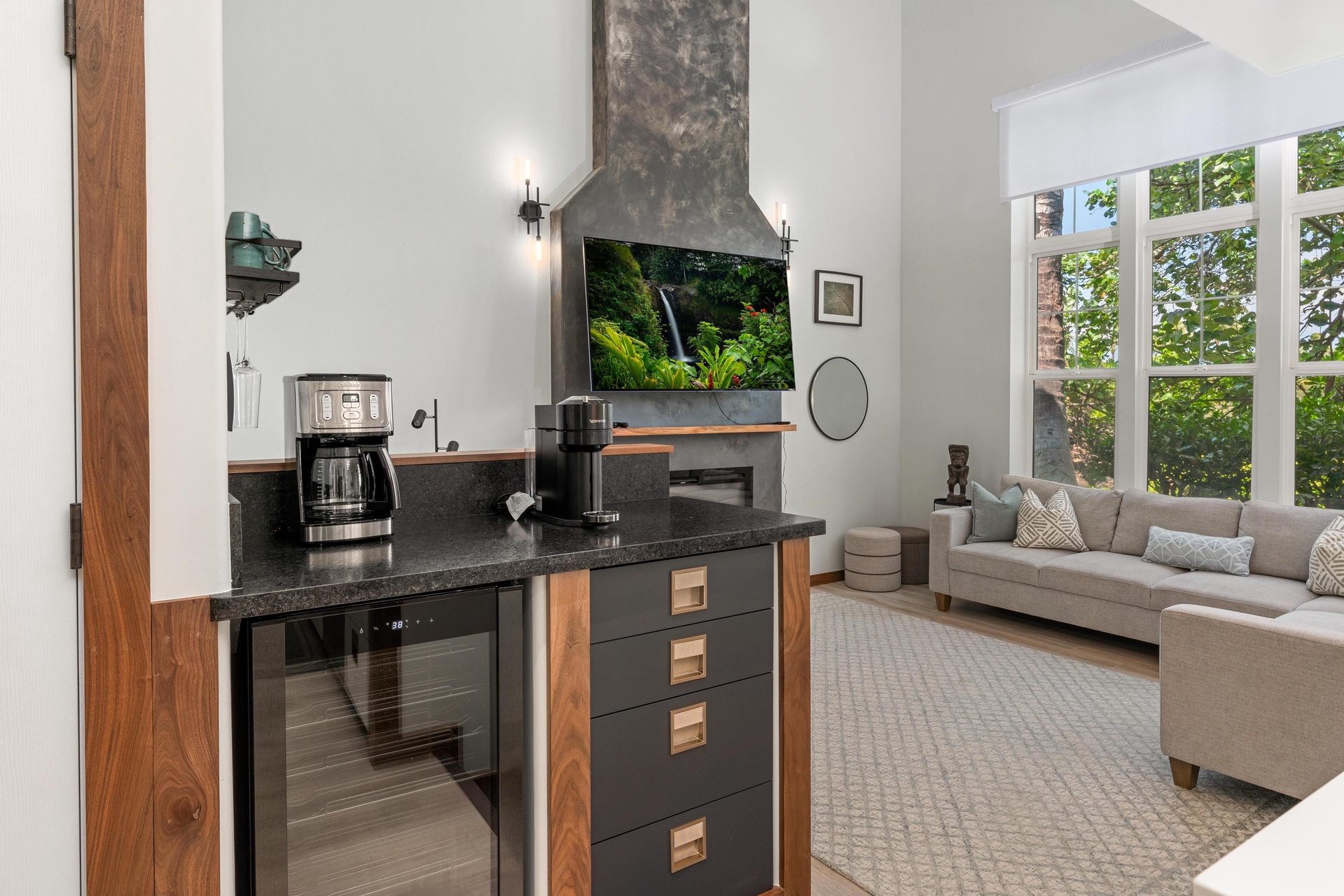 Relax in your stylish open-plan space where modern kitchen meets cozy living area, complete with coffee maker for morning rituals.