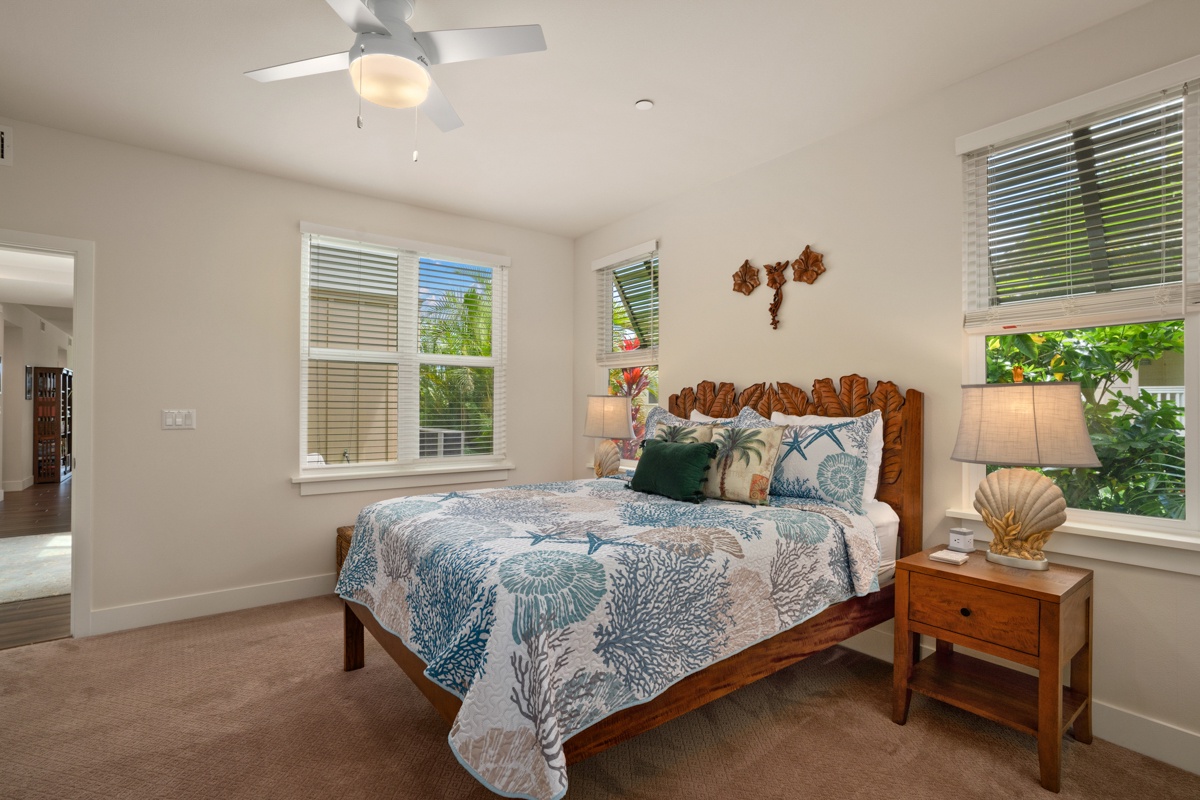 Drift off in your coastal-themed bedroom with breezy ceiling fan and tropical views through bright windows.