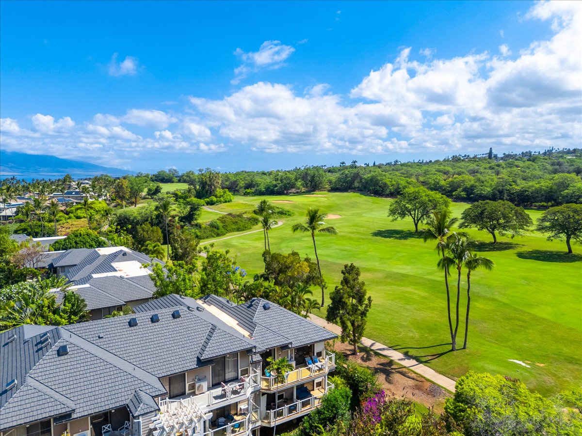 Stunning aerial view captures the property's coveted golf course frontage, with lush fairways and palm trees framing this tropical paradise location.