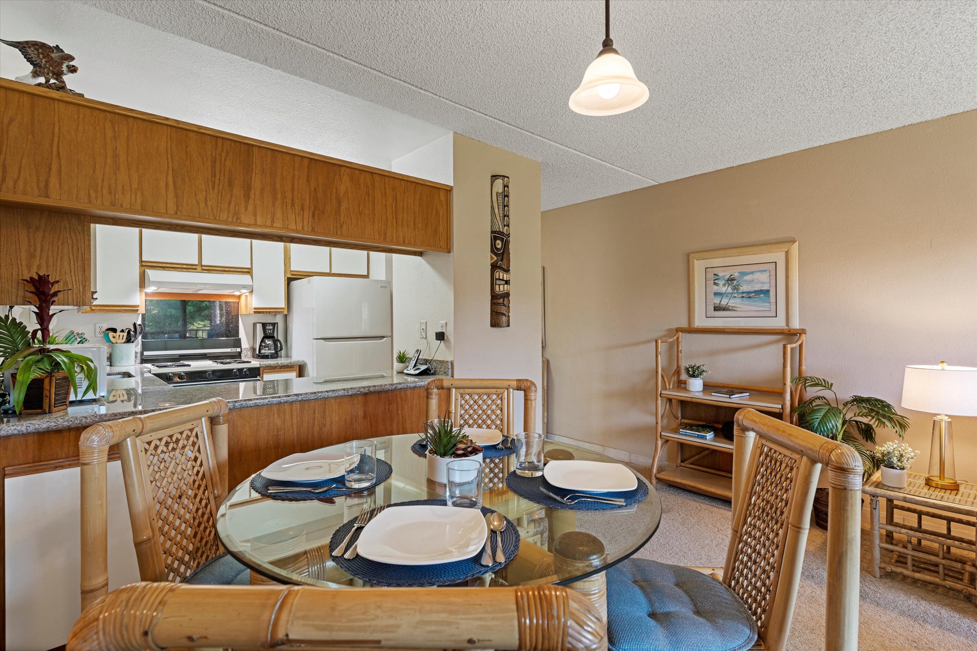 Picture yourself sharing a meal at this inviting glass-topped dining table, where coastal charm meets comfort. The open kitchen and cozy living space flow together, creating your perfect home base for unforgettable island memories.