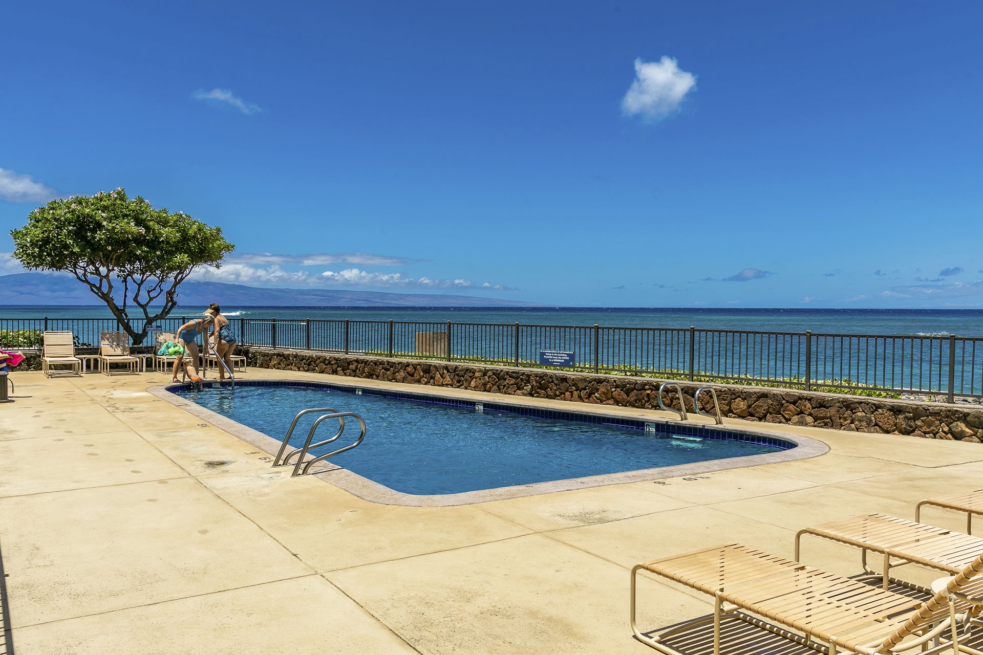 Stunning oceanfront pool area where you can swim, lounge, and soak in sweeping sea views under bright blue skies.