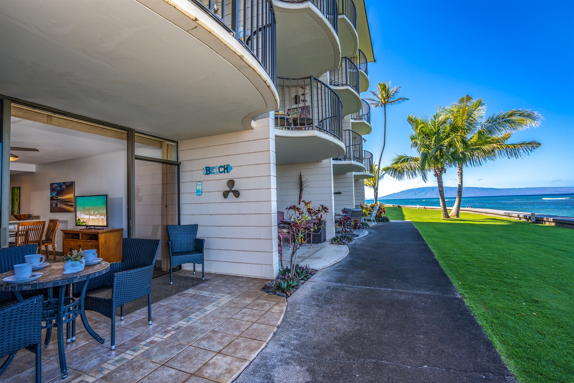 Sip your morning coffee on your private patio, steps from the ocean with palms swaying and soft grass beneath your feet.