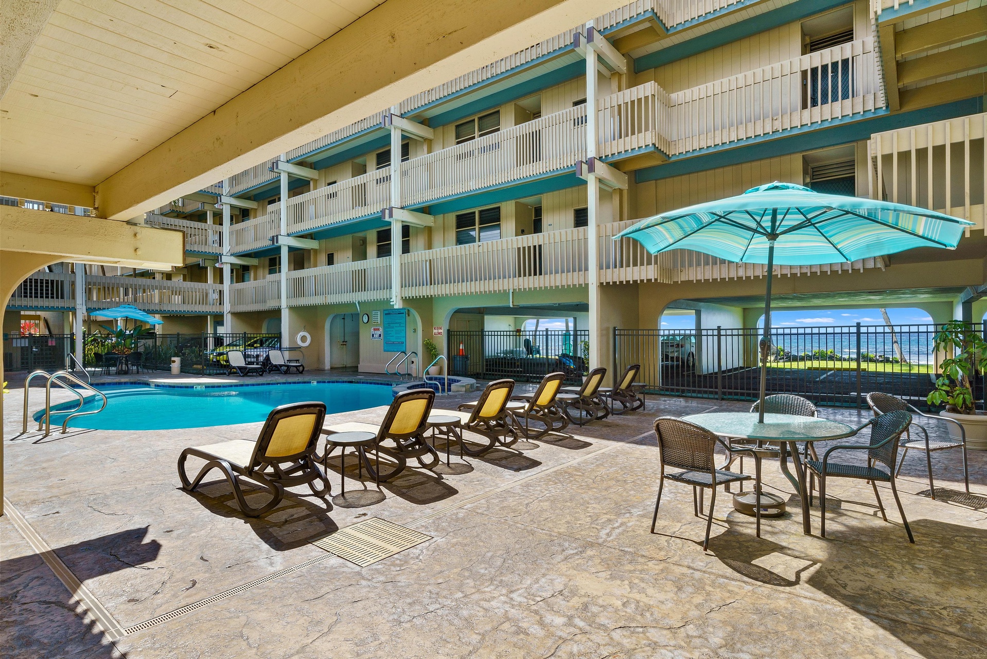 This covered pool deck offers your perfect retreat with lounge chairs, poolside dining, and views of the ocean just beyond—your personal oasis awaits.