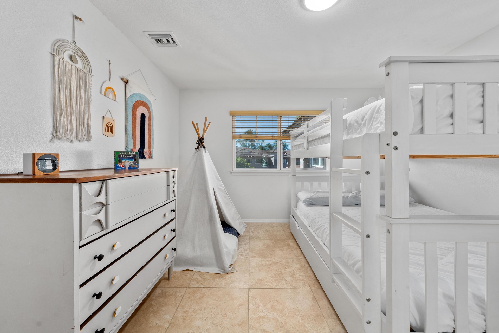 Your kids will love this bright bunk room with cozy teepee fort and cheerful artwork creating the perfect adventure base.