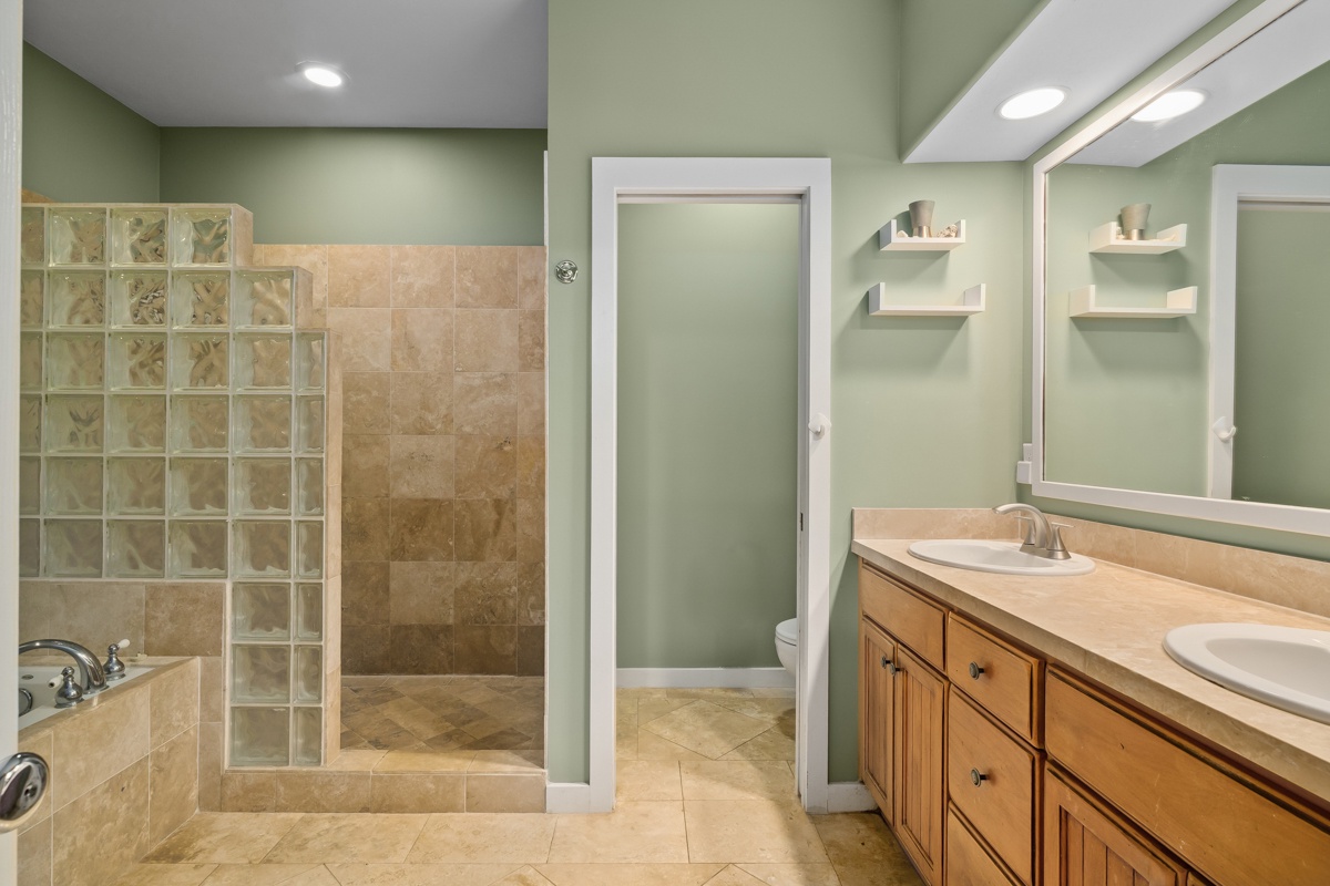 Refresh in your private spa-like bathroom with a walk-in shower, dual sinks, and tranquil sage-green walls that invite calm and comfort.
