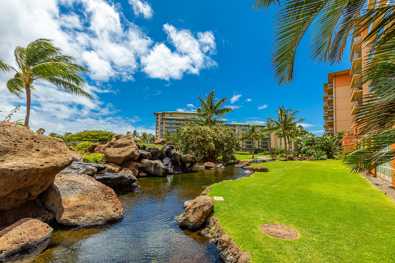 The property offers beautifully landscaped tropical grounds with natural rock features, serene water elements, and lush greenery surrounding the resort buildings.