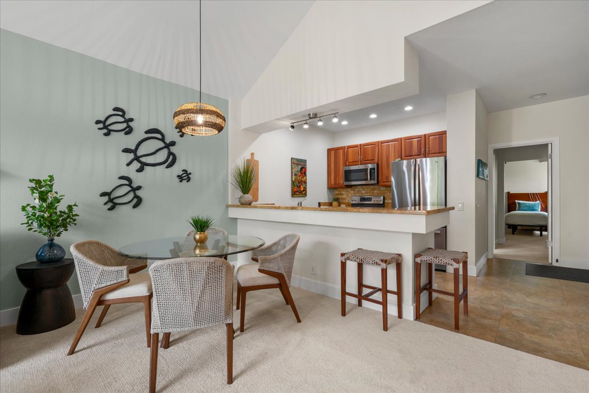 Gather around the bright dining area where coastal charm meets modern comfort. Enjoy meals beneath vaulted ceilings with a sleek kitchen and breakfast bar just steps away for your convenience.