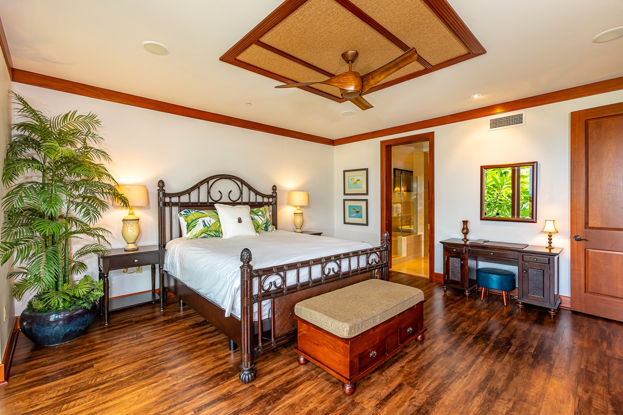 Unwind in this elegant bedroom, where warm wood details frame your island escape and a plush king bed invites restful nights beneath a tropical ceiling fan.